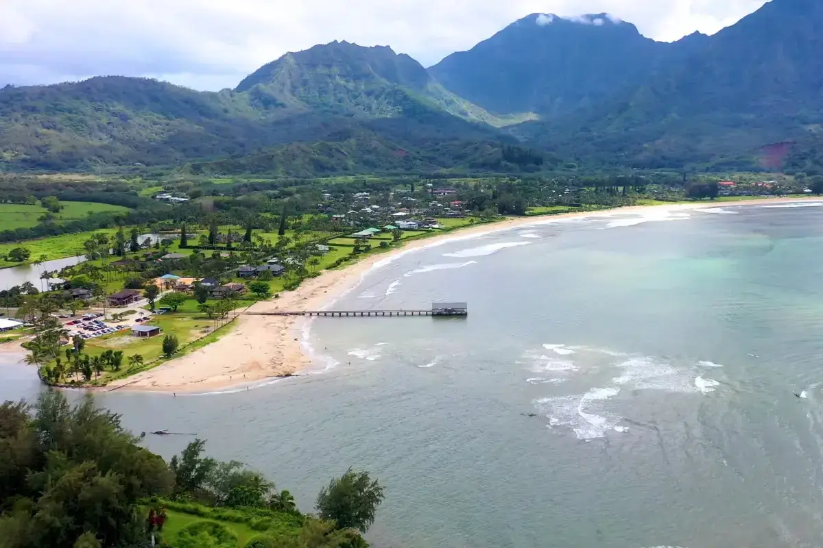 Scenic shoreline with mountains representing Hanalei Bay in Kauai